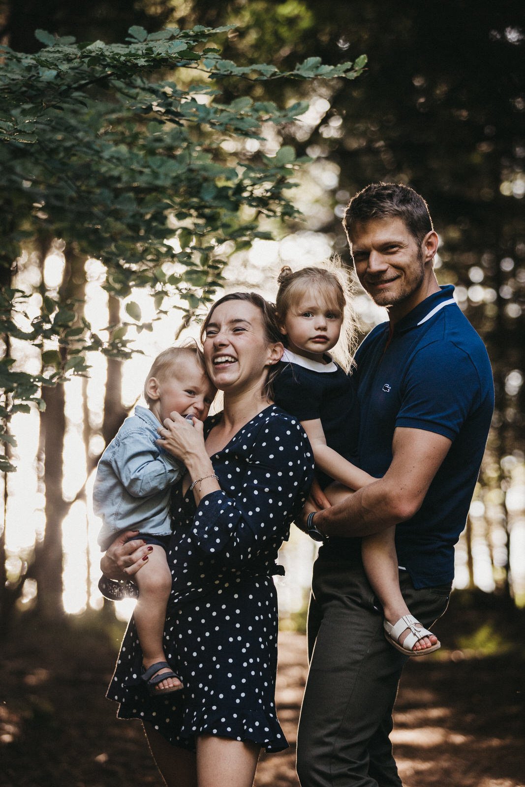 Photo de famille en forêt avec de beaux flous et de belles lumières du soleil couchant